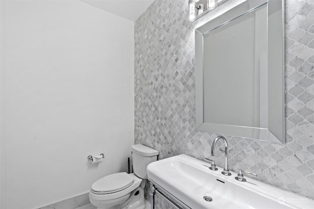 bathroom featuring vanity, decorative backsplash, and toilet