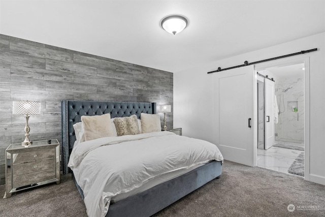 carpeted bedroom featuring connected bathroom, a barn door, and wood walls