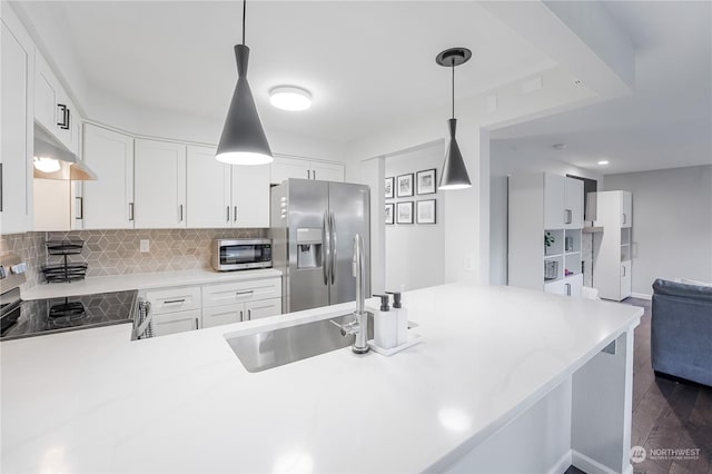 kitchen featuring appliances with stainless steel finishes, pendant lighting, white cabinetry, and kitchen peninsula