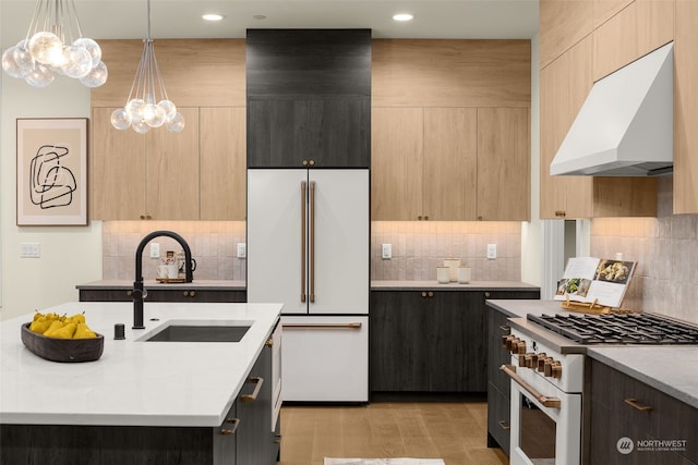 kitchen featuring sink, light stone counters, ventilation hood, light brown cabinetry, and high end appliances