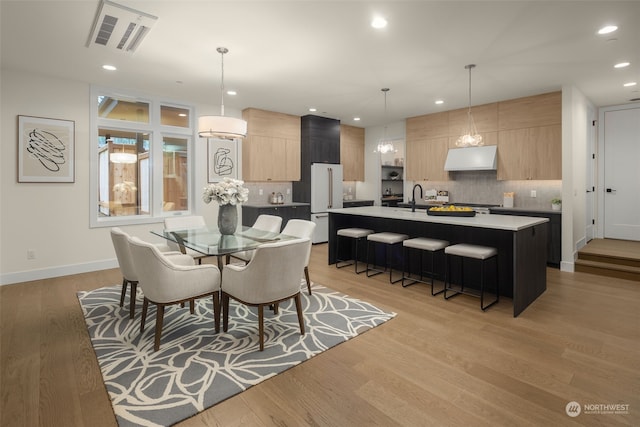 dining room featuring sink and light hardwood / wood-style floors