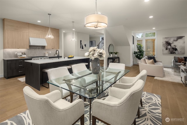 dining area featuring sink and light wood-type flooring