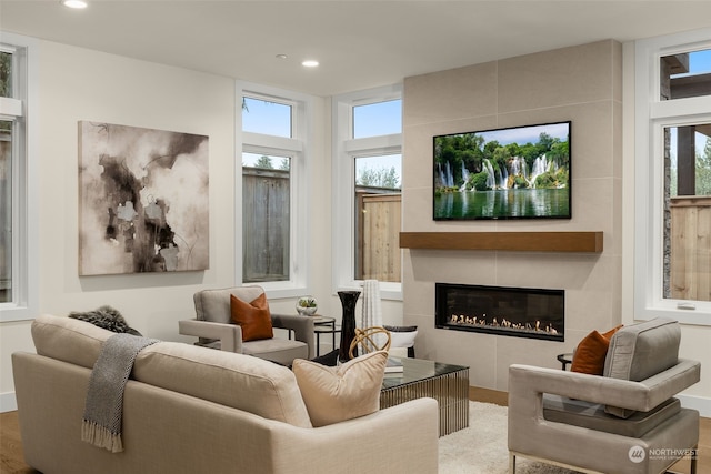 living room featuring hardwood / wood-style floors and a tiled fireplace