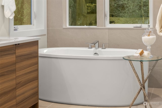 bathroom featuring tile patterned floors, a bathtub, and vanity