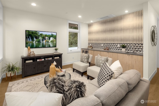 living room with light hardwood / wood-style floors and sink