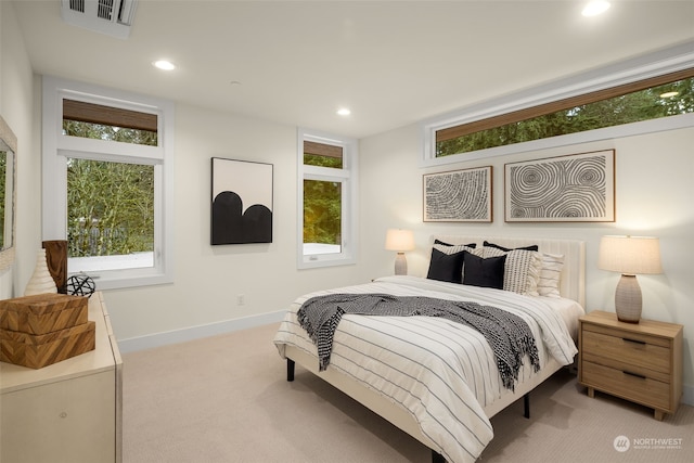 bedroom featuring multiple windows and light carpet