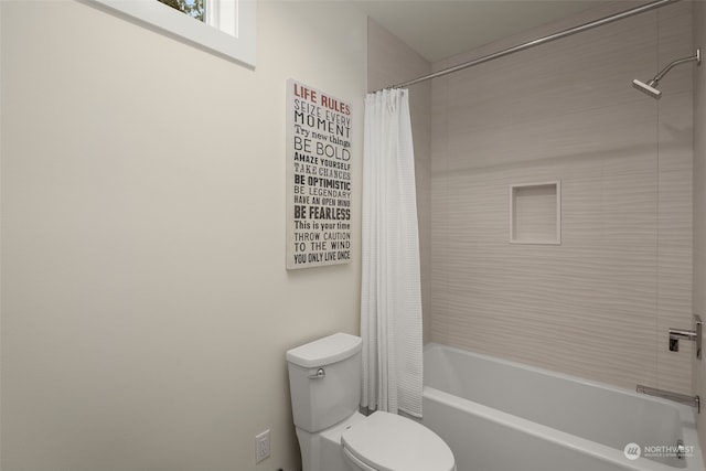 bathroom with toilet and shower / bath combo with shower curtain