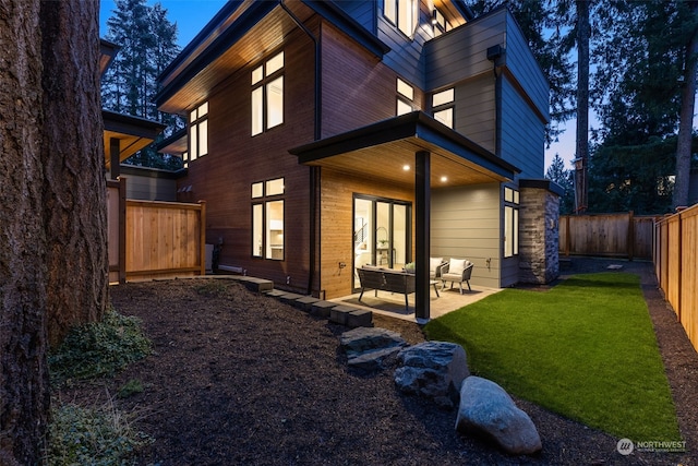 back of house with an outdoor hangout area, a patio, and a yard