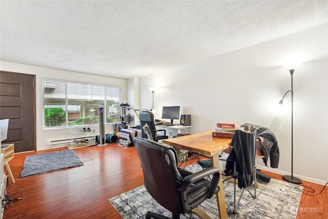 office with hardwood / wood-style floors, a textured ceiling, and baseboard heating