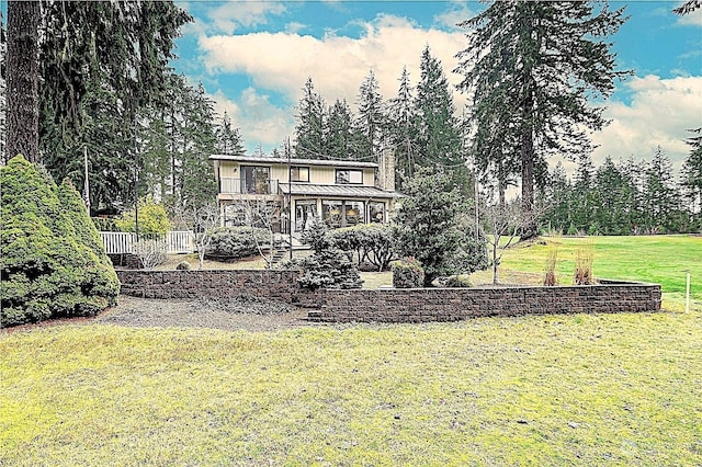 rear view of house with a yard and a deck