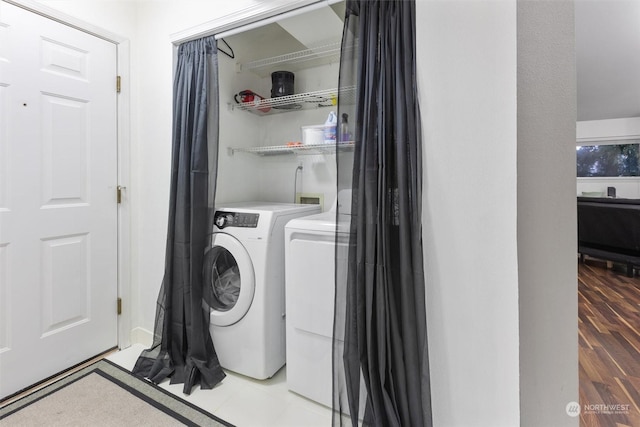 washroom with washing machine and dryer and tile patterned floors