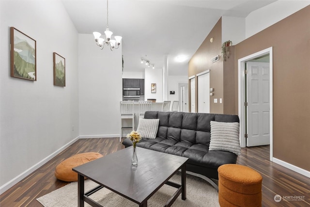 living room with lofted ceiling, dark wood-type flooring, and a chandelier