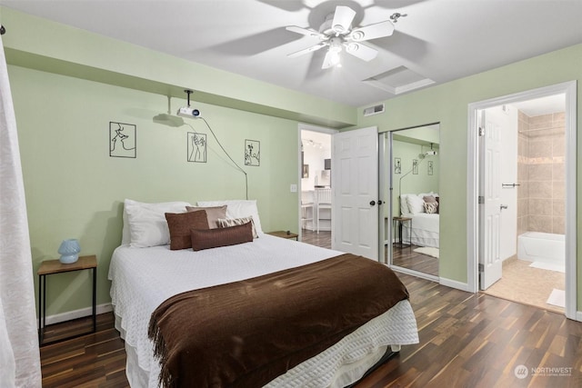 bedroom with dark wood-type flooring, ceiling fan, and connected bathroom