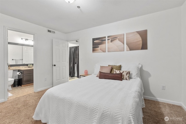 bedroom with light carpet and ensuite bath