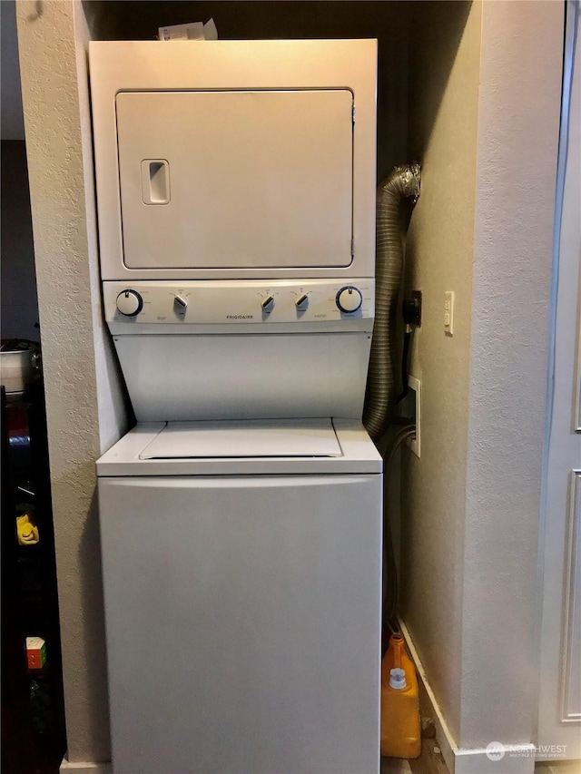 washroom with stacked washing maching and dryer