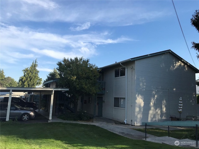 view of home's exterior featuring a carport and a lawn