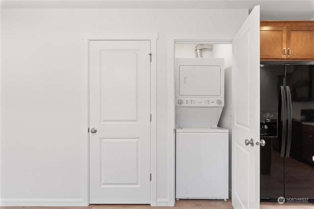 clothes washing area featuring stacked washing maching and dryer