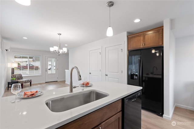 kitchen with sink, a wall mounted AC, a chandelier, decorative light fixtures, and black appliances