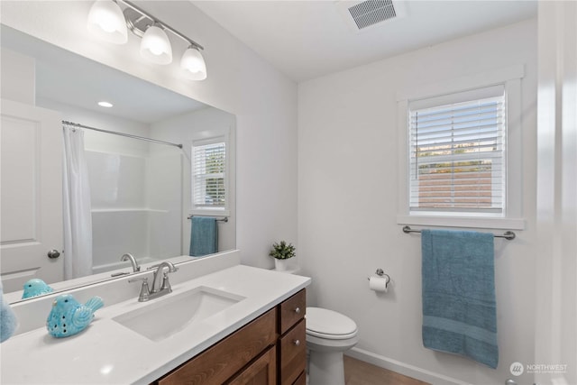 bathroom featuring vanity, curtained shower, and toilet