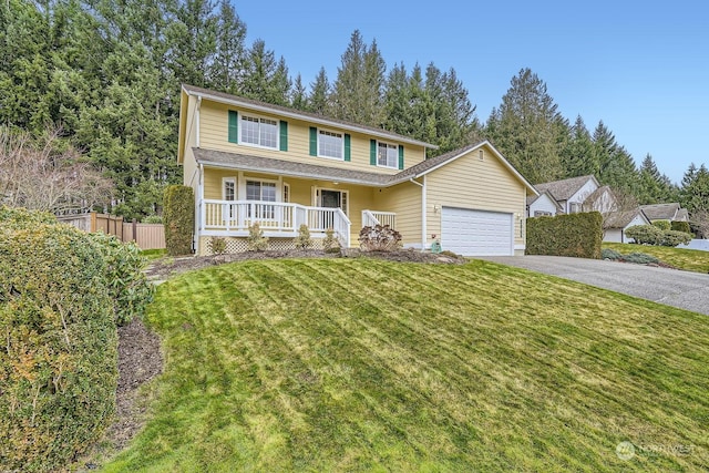 view of property featuring covered porch, a front lawn, and a garage