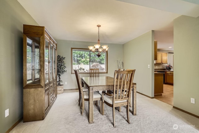 dining room with a chandelier and light carpet