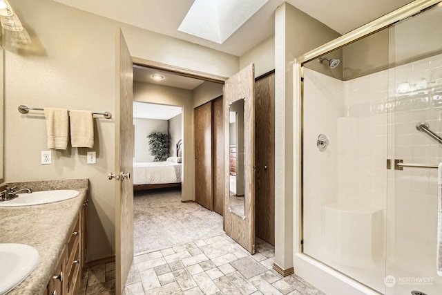 bathroom featuring a skylight, an enclosed shower, and vanity