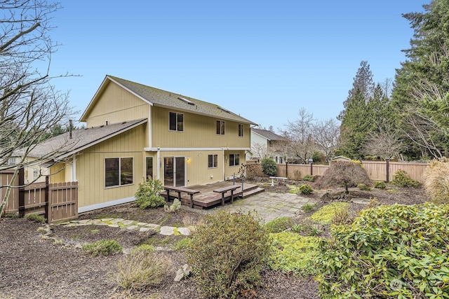 rear view of property featuring a wooden deck