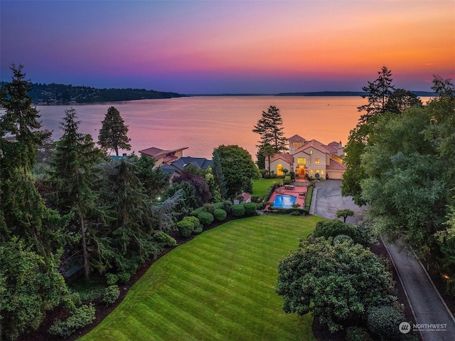 aerial view at dusk featuring a water view