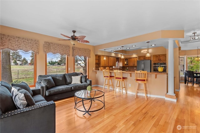 living room with ceiling fan and light hardwood / wood-style flooring