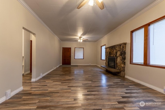 unfurnished living room featuring dark hardwood / wood-style flooring, a stone fireplace, ceiling fan, and ornamental molding