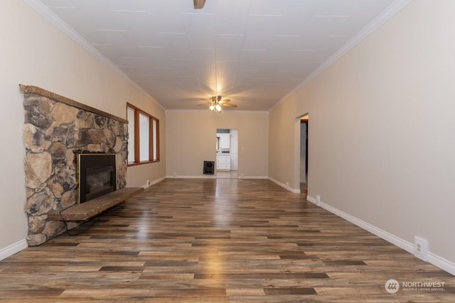 unfurnished living room featuring hardwood / wood-style floors, ceiling fan, a stone fireplace, and crown molding