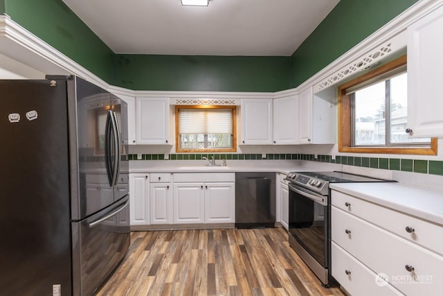 kitchen with white cabinetry, sink, stainless steel appliances, dark hardwood / wood-style floors, and backsplash