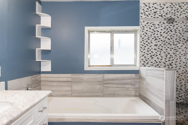 bathroom featuring vanity and a tub to relax in