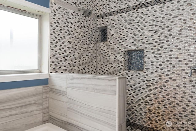 bathroom featuring tiled shower and plenty of natural light