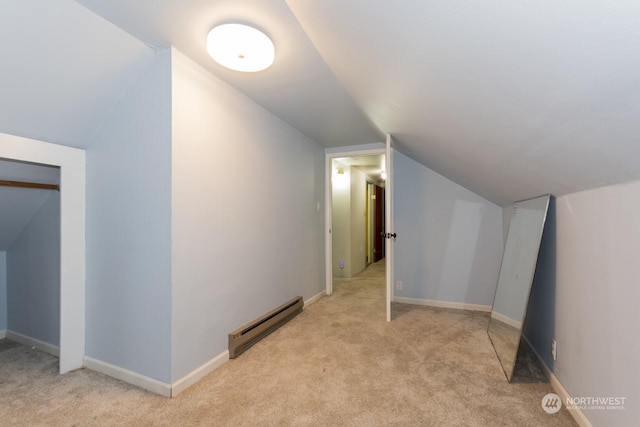 additional living space with light carpet, lofted ceiling, and a baseboard heating unit