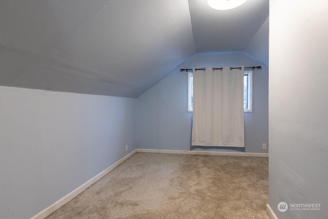 bonus room with light carpet and vaulted ceiling