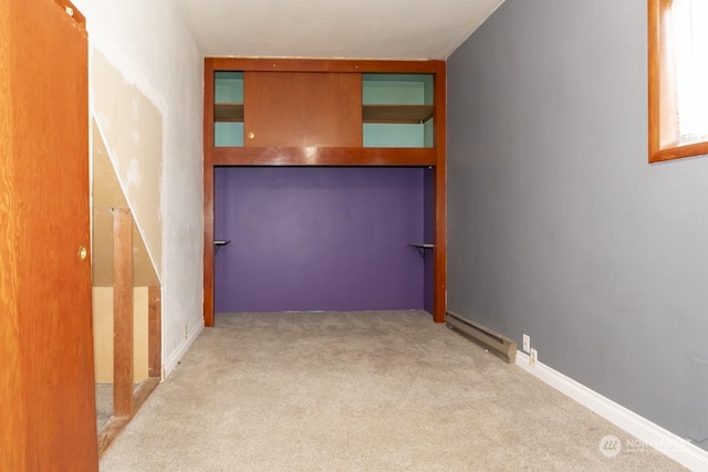 hallway featuring light colored carpet and a baseboard radiator