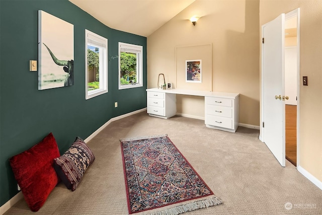 carpeted bedroom featuring built in desk and vaulted ceiling