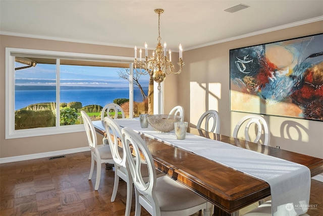 dining room featuring dark parquet flooring, a chandelier, a water view, and plenty of natural light