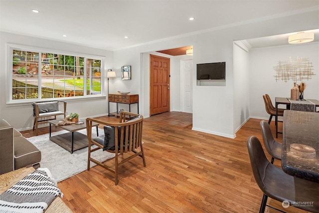 living room featuring crown molding and light hardwood / wood-style flooring