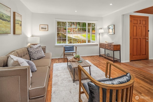 living room with light wood-type flooring and ornamental molding