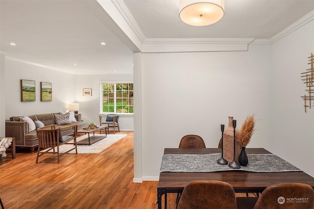 dining space with ornamental molding and light hardwood / wood-style floors