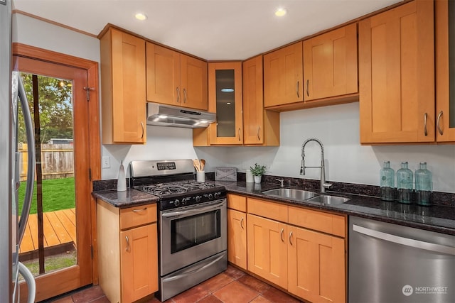 kitchen featuring dark stone counters, appliances with stainless steel finishes, tile patterned floors, and sink