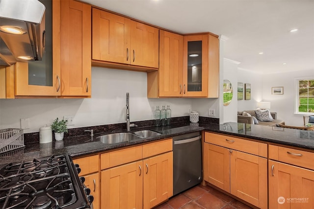 kitchen with dark stone counters, dishwasher, and sink