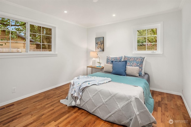 bedroom featuring wood-type flooring and ornamental molding