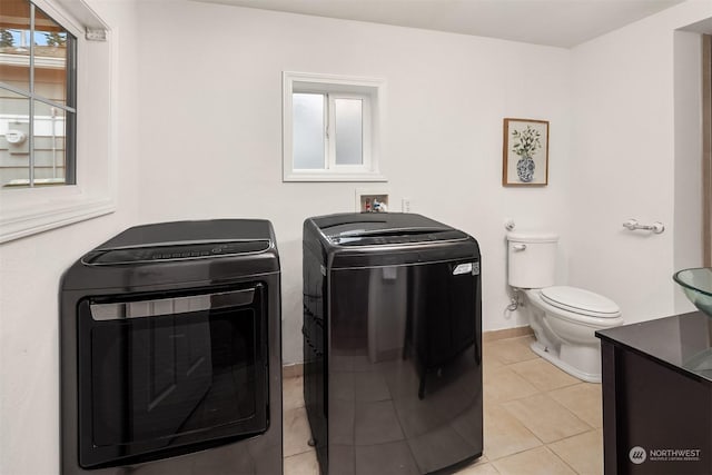 washroom with separate washer and dryer, a healthy amount of sunlight, and light tile patterned floors