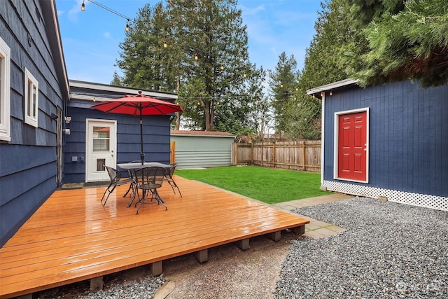 wooden deck featuring a yard and a storage unit