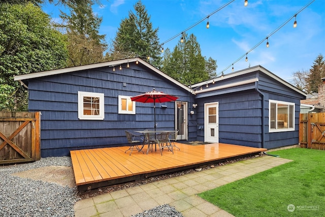 rear view of property with a lawn and a deck