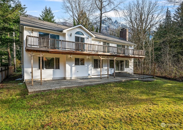 rear view of house featuring a yard, a patio area, and a wooden deck