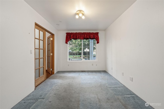 carpeted empty room featuring french doors